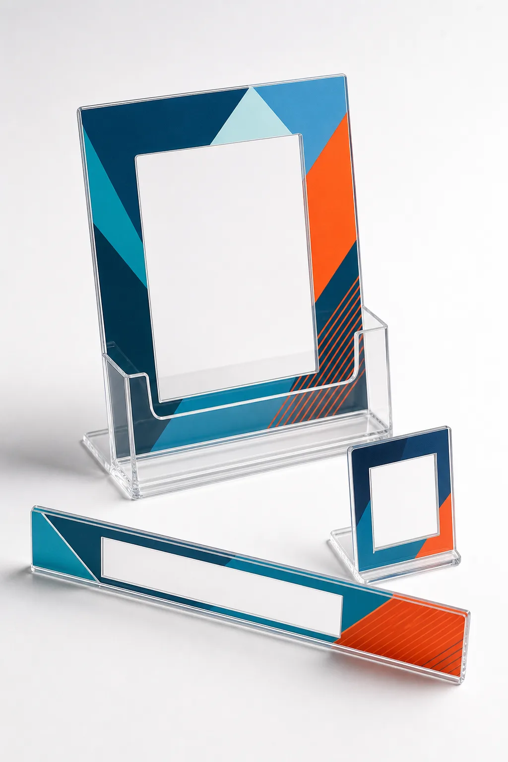 Three-piece acrylic POS kit for a consumer brand — clear countertop POP display with printed backer, shelf-edge strip, and small tabletop standee arranged as one retail set
