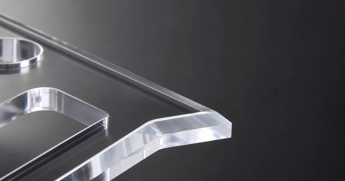 Macro of four acrylic edge finishes side by side — CO2 laser, diamond polished, flame polished, and CNC machined PMMA edges under directional studio light