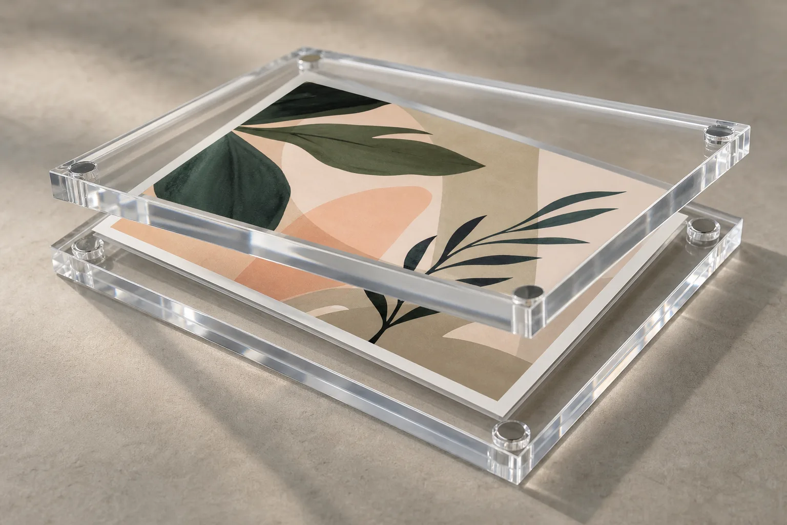 Magnetic two-piece clear acrylic frame partly opened to swap an art print, polished PMMA panels with embedded magnets catching the light on a gallery counter