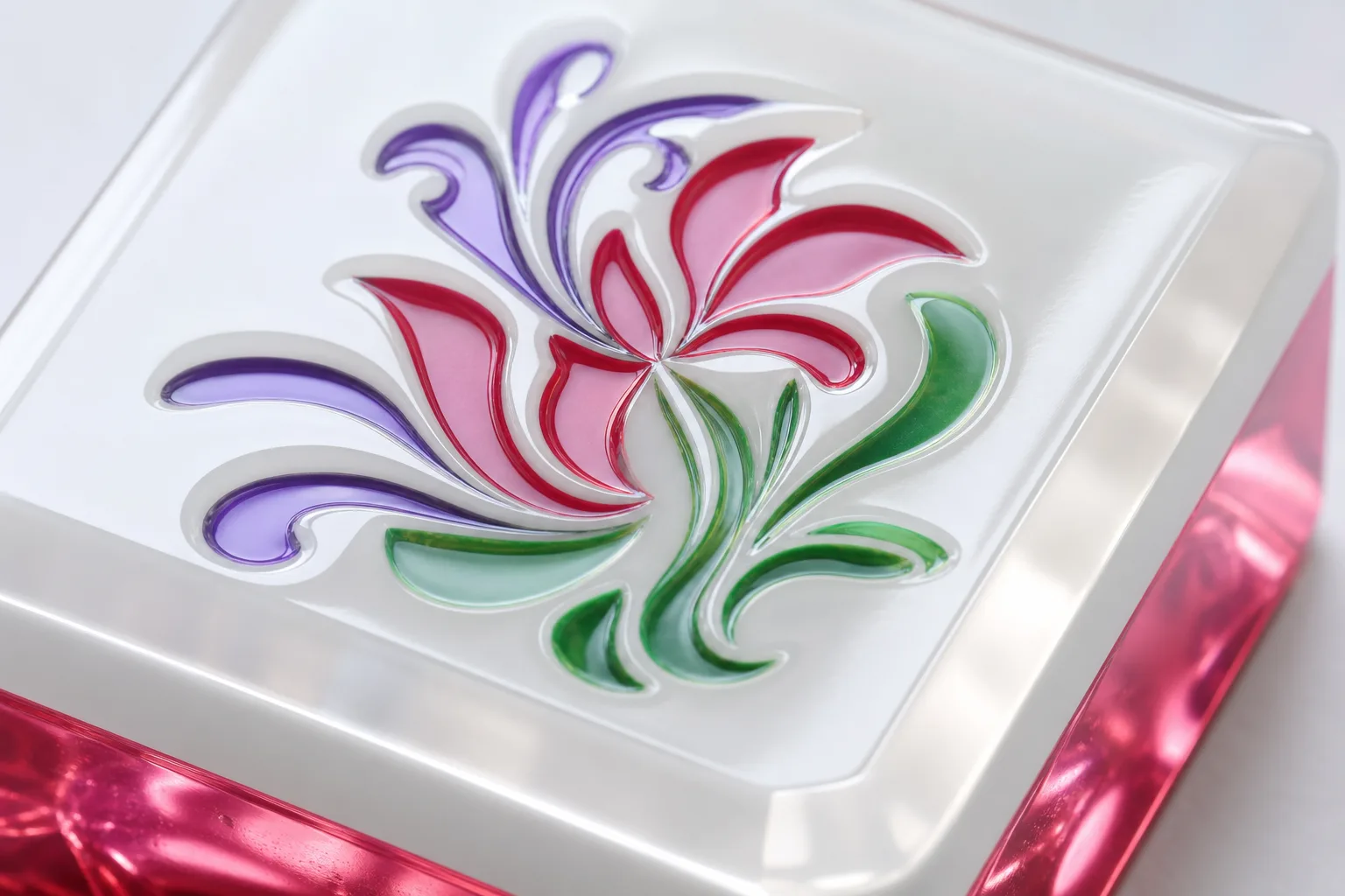 Macro of a custom acrylic mahjong tile face showing engraved artwork with UV-printed color filled into the recess, the glossy cast PMMA surface catching light around the engraving