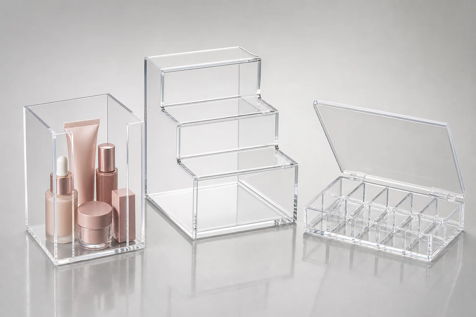 Custom plastic display boxes built in clear cast acrylic — an open five-panel countertop box, a three-layer tiered display box, and a compartmented sample presentation box