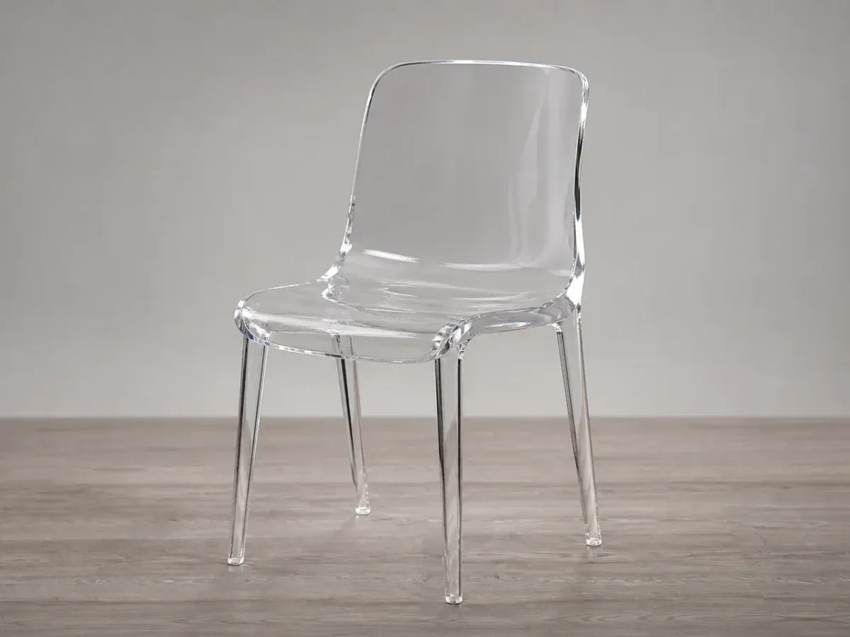 Single clear cast acrylic dining chair with a curved molded seat and back photographed against a soft neutral backdrop