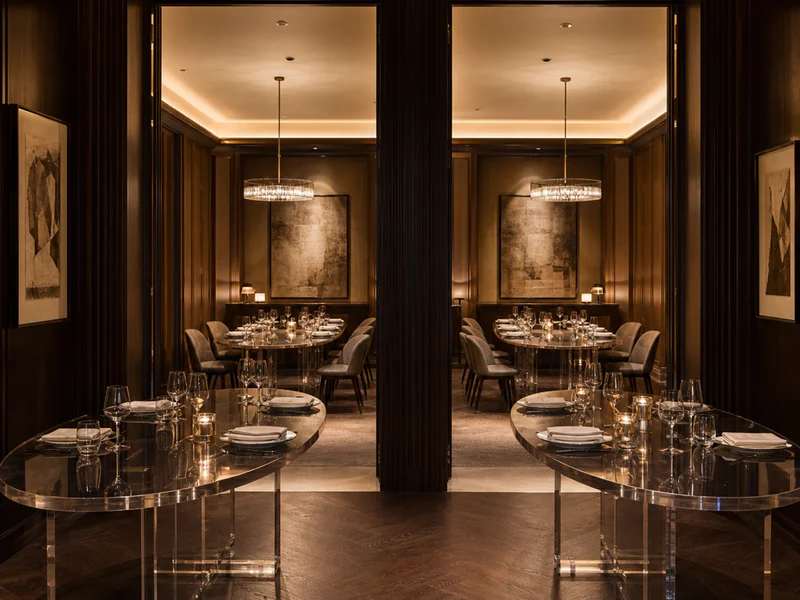 Boutique Hotel Group — Oval Private-Dining Table Set. 8 tables across 8 properties · 35mm smoke-tinted cast acrylic · 2.0 × 1.0m oval with boat-edge profile · trestle base · diamond polish on every visible edge · custom Pantone-matched smoke tint validated at sample with color chip · 8-property batch color match