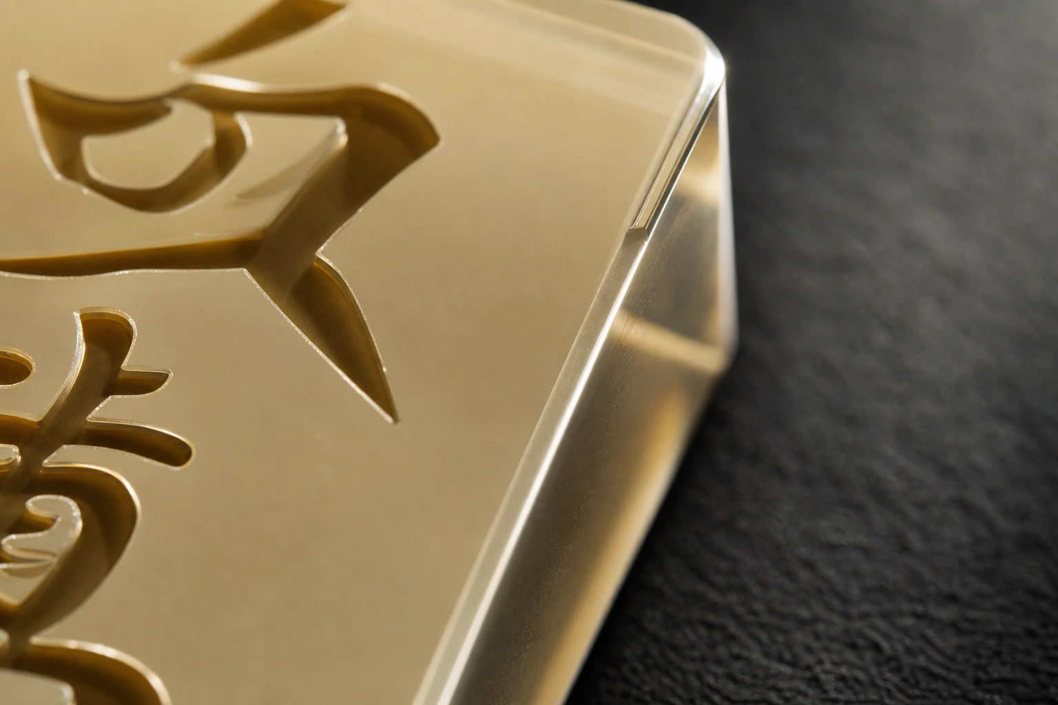 Extreme close-up of acrylic mahjong tile edge showing CNC-chamfered 0.3 mm edge geometry and deep laser-engraved character channel in translucent cast PMMA
